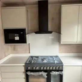 Newly installed kitchen with range cooker and black extractor