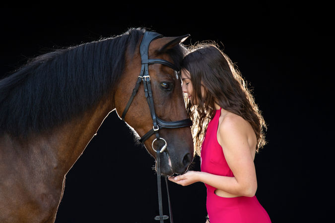 Cavalière et son cheval lors d'une séance photo sur fond noir
