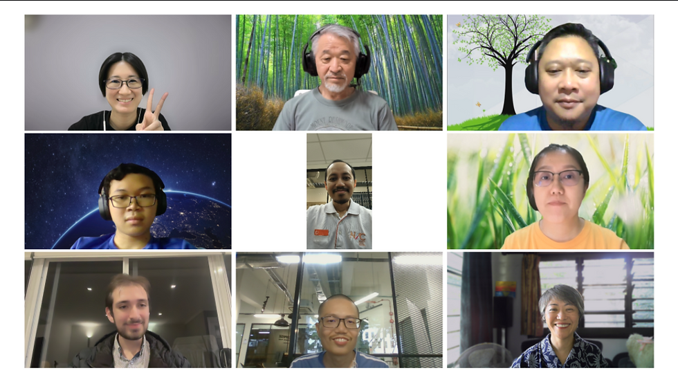 Nine-person video call grid with smiling faces and varied virtual backgrounds; one woman flashes a peace sign.