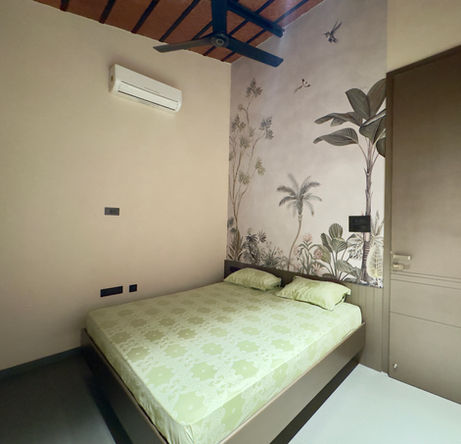 Bedroom at The Terracotta Loft with tropical mural wall.