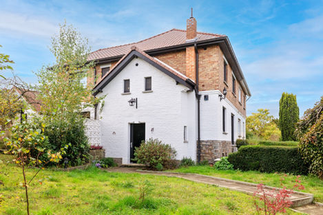 a white house with a brick roof and a chimney