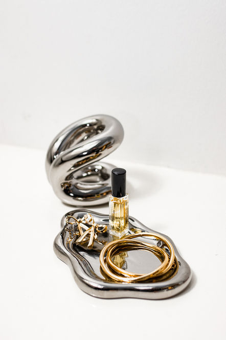 Silver tray with jewelry and perfume on white background, photography.