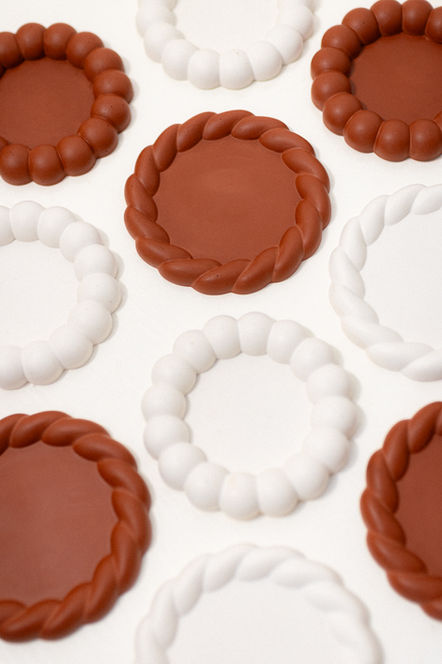 Red and white coasters arranged in a pattern on a white surface.