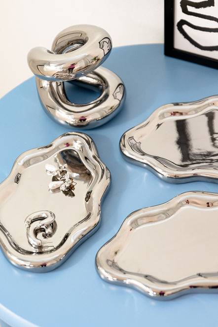 Silver trays and abstract object on blue table Photography, home decor