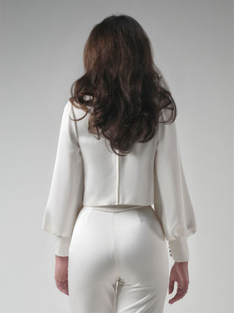 A beautiful bridal top made of satin. It features a boat neck and trumpet sleeves, with double cuffs and fabric buttons.