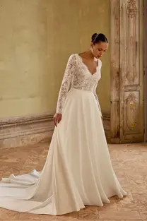 Front view of Kenya ivory fit and flare bridal gown featuring V-neckline and allover lace with overlay skirt