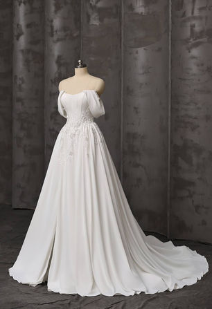 For the curvaceous bride who dreams of a fairy - tale moment! The structured satin bodice, paired with a timeless scoop neckline, creates a flattering silhouette that accentuates the figure beautifully. The flowing chiffon skirt, with a daring slit, lets you move with grace. Detachable draped sleeves are definitely clever design. Delicate floral embroidery at the waist adds a touch of romance. Embrace your beauty and walk down the aisle in this gown that celebrates your curves and your love story.