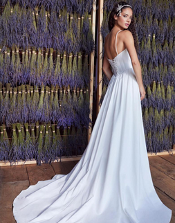 Romantic satin bridal gown with sweetheart scoop neckline, corset back and flowing skirt with slit.