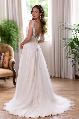 Apollo by Nikki Flynn True Bride.
True Bride Stockists Northern Ireland
Nikki Flynn Stockists Northern Ireland.
This vintage inspired wedding dress is glamour and elegance at its finest. This bridal gown will turn heads with its ‘Art Deco’ inspired hand beaded and sequin design on soft tulle over a strapless satin bodice. This style is so romantic and elegant with its floaty waterfall scallop edged beaded sleeves. A crystal and pearl encrusted belt at the waist cinches in the waist, and the beading continues down over the hips to a soft tulle full skirt with tulle godet inserts to complete the look. Zip up back finished with buttons.