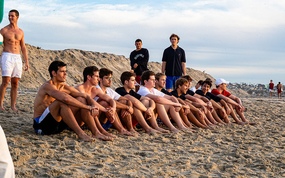 Nautica Shoot - Men's Rowing team sits along the beach