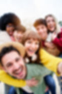 Vertical photo of Cheerful group of happy friends taking smiling selfie in piggyback. Thre