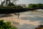Male surfer walking barefoot along the beach toward Lazy Left surf spot with board under arm