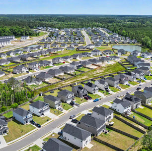 Aerial view of a residential neighborhood in Hinesville featuring single-family homes and a community pond