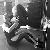 woman doing a sit-up while holding a tire