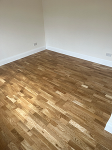 Empty room featuring new light wooden parquet flooring installation.