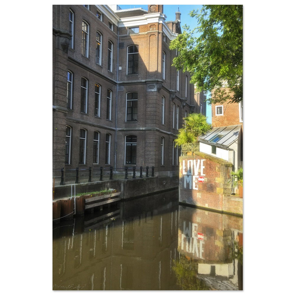 Historic buildings along a canal, with reflections in the calm water.