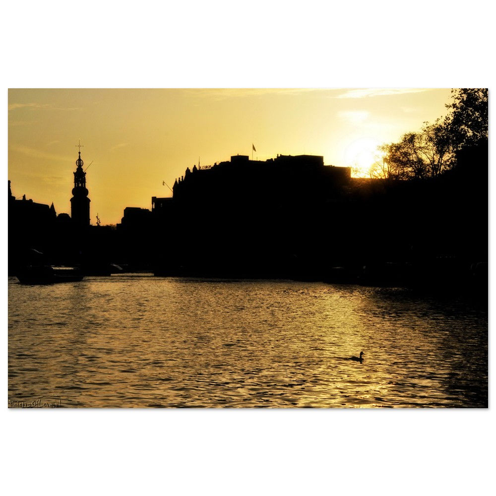 Golden sunset over river silhouettes buildings; reflective water scene background.