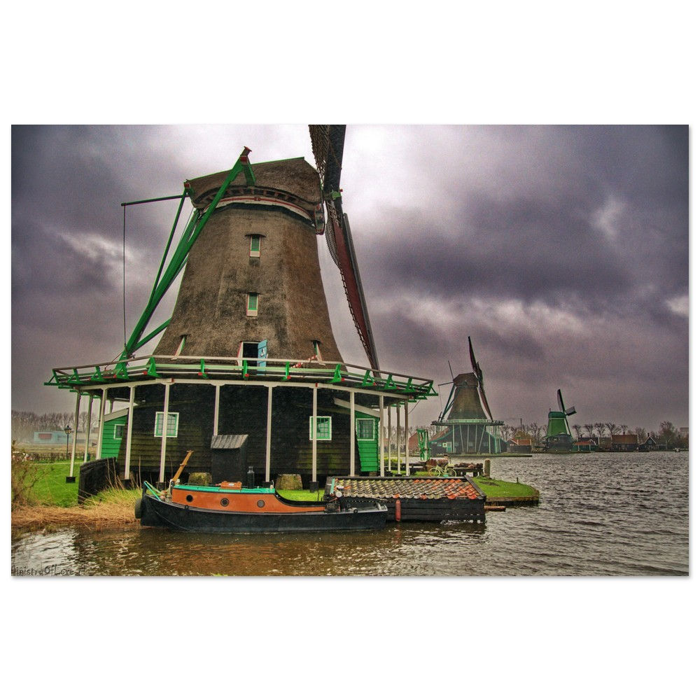 Historic windmills stand tall on water under a cloudy, overcast, dramatic sky.