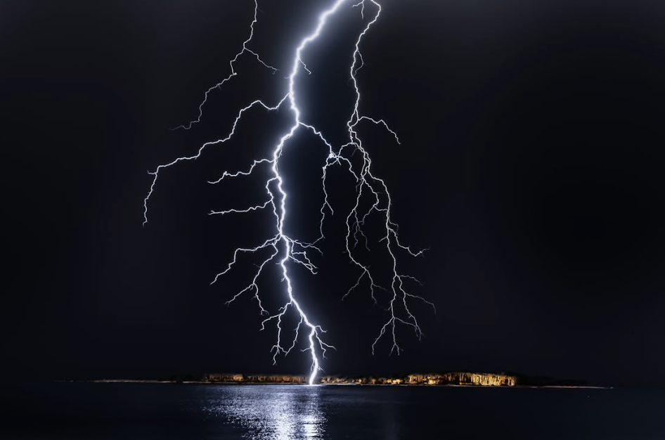 Severe Gold Coast storm with lightning striking near the coast, showing weather conditions that often cause air conditioner breakdowns and electrical overloads.