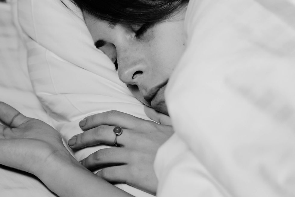 Femme endormie paisiblement dans son lit, symbole du sommeil et du bien-être des femmes à différents cycles hormonaux