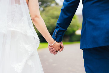 Bride and groom holding hands, walking on a road. Wedding Photography in Yorkshire.