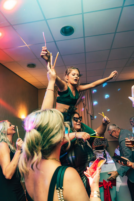 Woman celebrating on shoulders with a sparkler at a party background