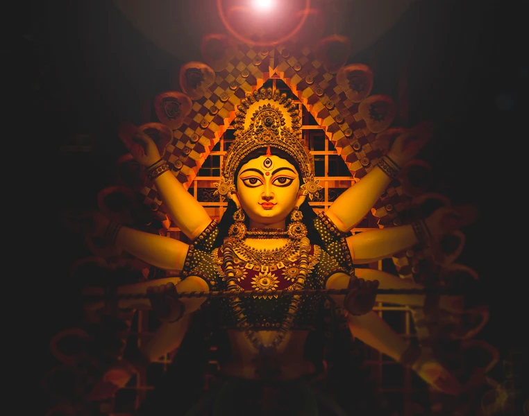 a statue of a woman with a crown on her head has a third eye on her forehead