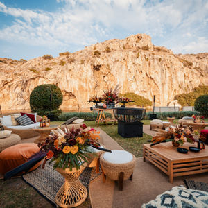 Outdoor lounge area with bohemian decor, against a mountain backdrop