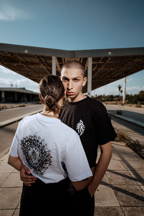 Couple in black and white T-shirts, modern architecture background