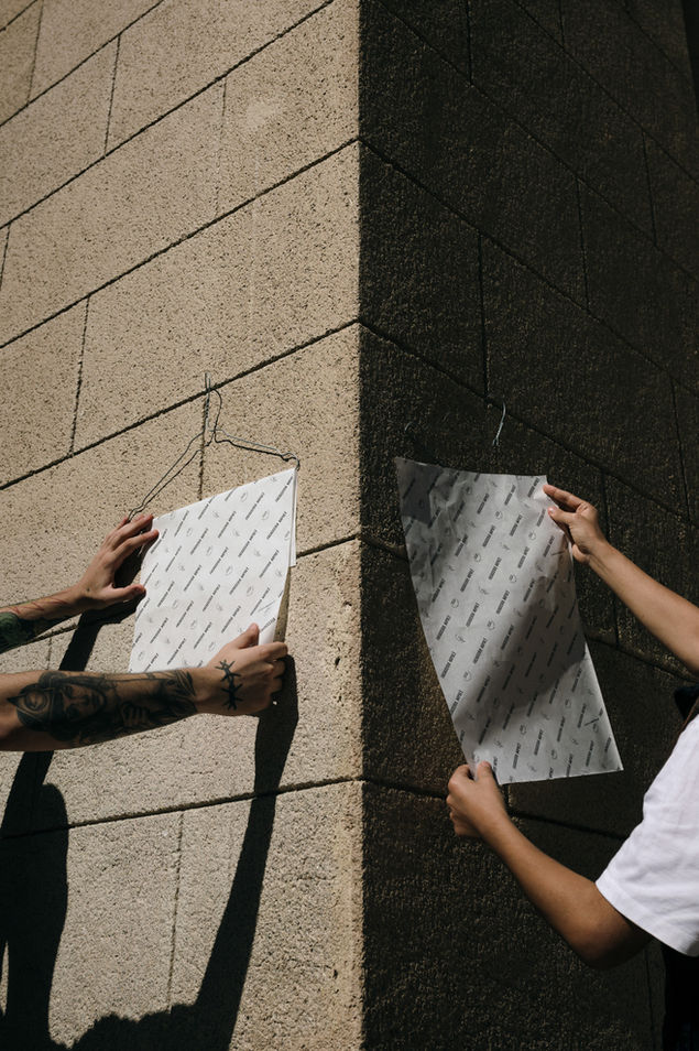 Hands hanging branded posters on wall