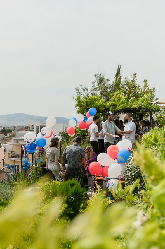 Group celebrating outdoors with red, white, and blue balloons
