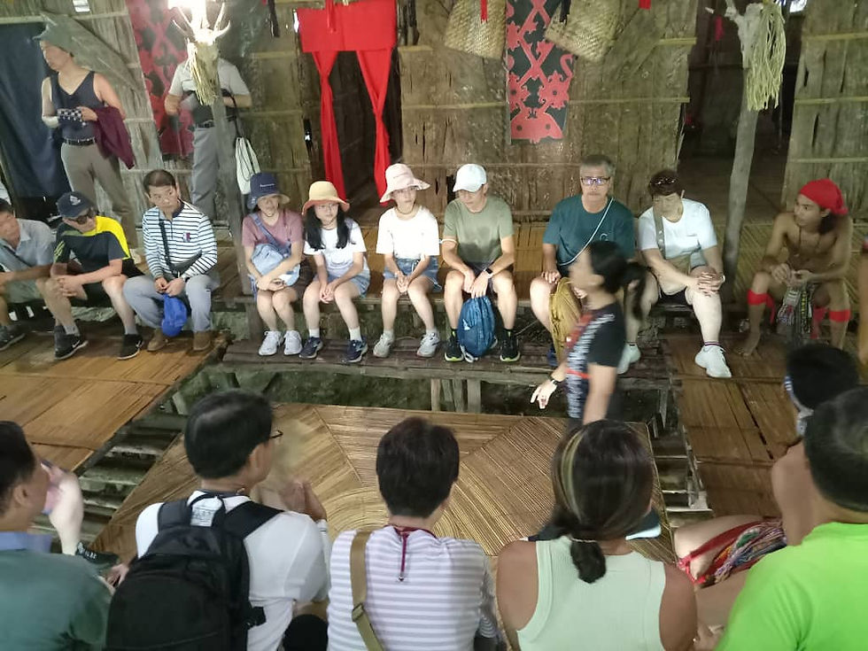 Visitors in Rungus house for a demonstration of a traditional game.