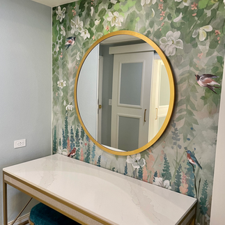 A round mirror with a polished brass frame.