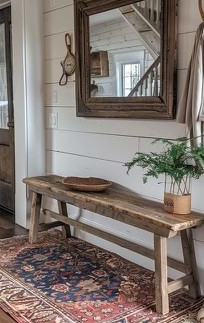 A farmhouse entryway showing a rustic bench by the doorway.