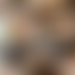 A industrial style living area with exposed brick walls, a black leather sofa, and exposed AC ductwork overhead