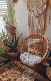 A bohemian sitting area with lots of potted plants, a macrame chair, and a wall hanging tapestry.