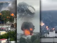 Captura de pantalla difuminada de un video de celular que muestra la silueta urbana de Moscú durante el día. En el fondo, grandes columnas de humo negro y gris se elevan hacia el cielo desde la zona de la refinería afectada.