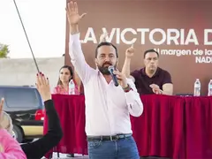 diputado arturo avila de morena en un evento al aire libre levantando la mano