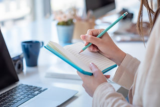 Frau notiert sich Notizen im Notizbuch