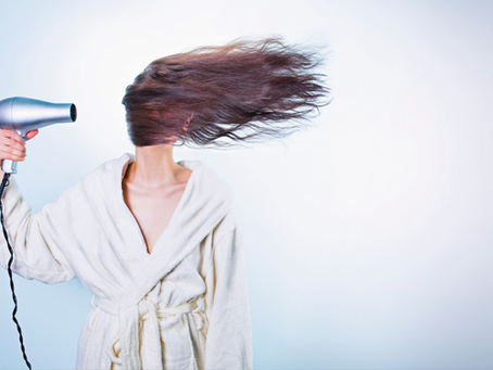 mujer secándose el cabello con aire fuerte