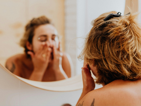 woman washing her have in her bathroom in front of the mirror