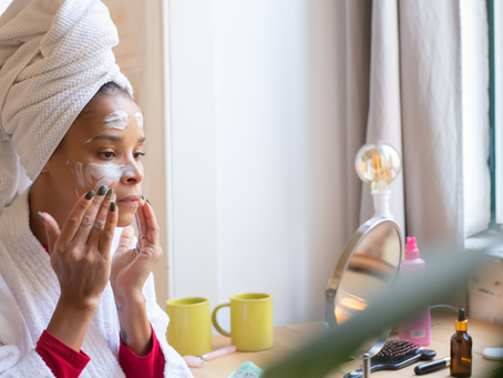 mujer en su baño aplicándose crema facial