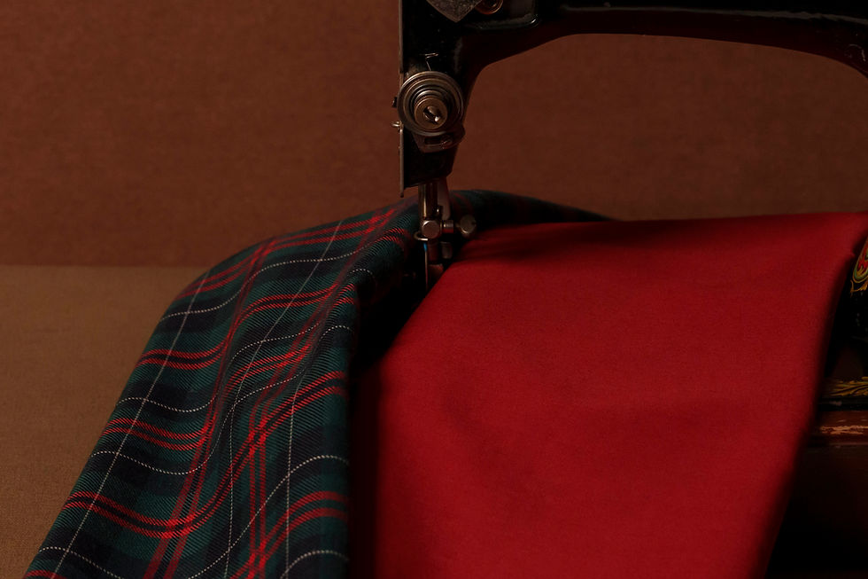 a red and green plaid fabric, a red plain fabric and a sewing machine
