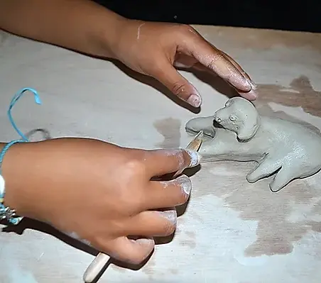 Nadia Siegler art thérapeute faisant du modelage avec un enfant.webp