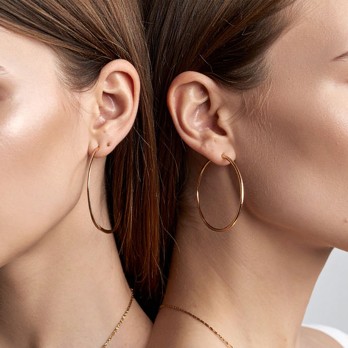 Side profile of woman wearing a brilliant round-cut gold earring