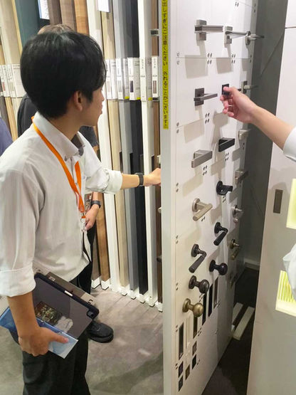 ドアノブのサンプルを見る新入社員