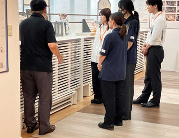 床材の違いを教わる新入社員