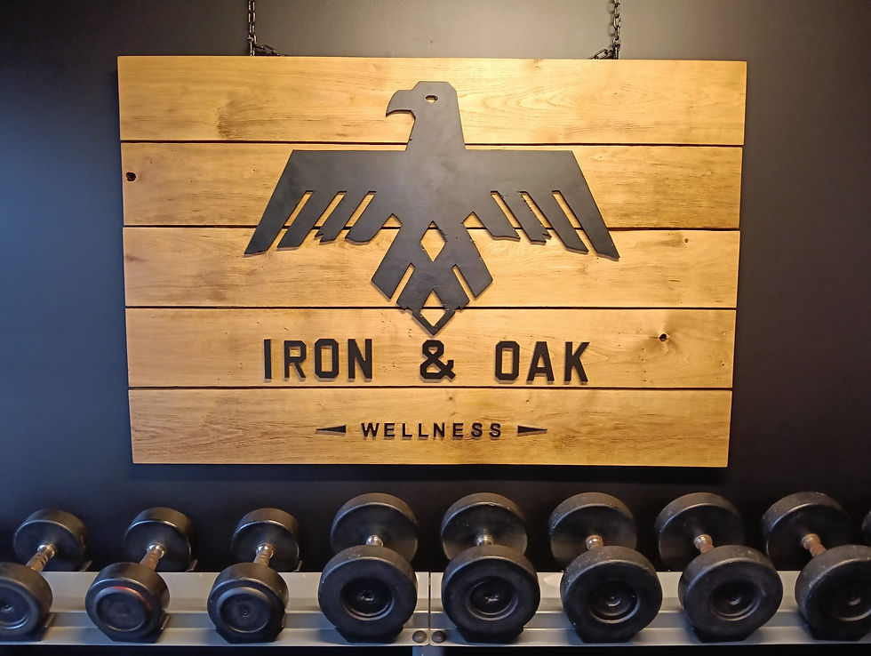 Wooden Iron & Oak Wellness sign with dumbbells in front, landscape, warm tones