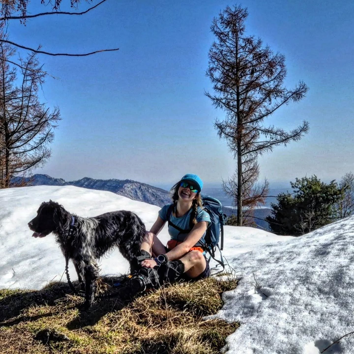8. Alessia Masciocchi seduta con il cane Rein sul limitare della neve, pausa durante camminata in montagna con fibromialgia