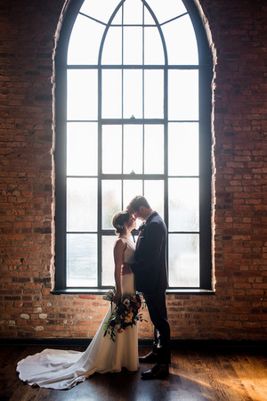 couple in front of large window at clementine hall